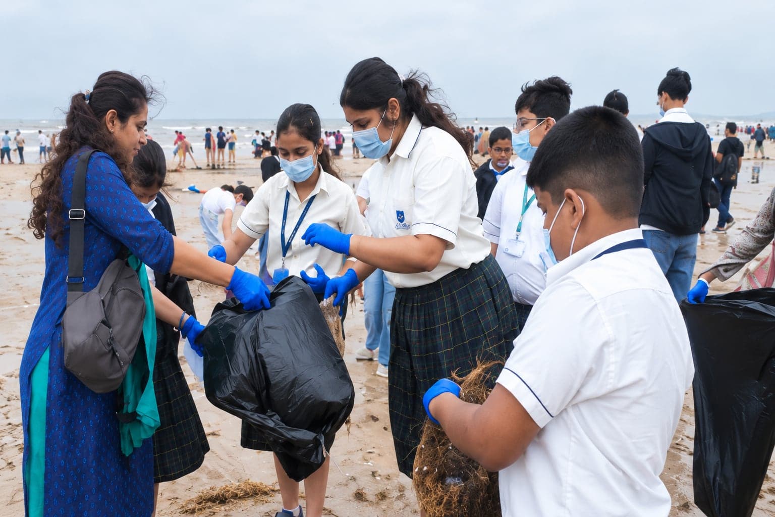 Students collecting waste on a beach