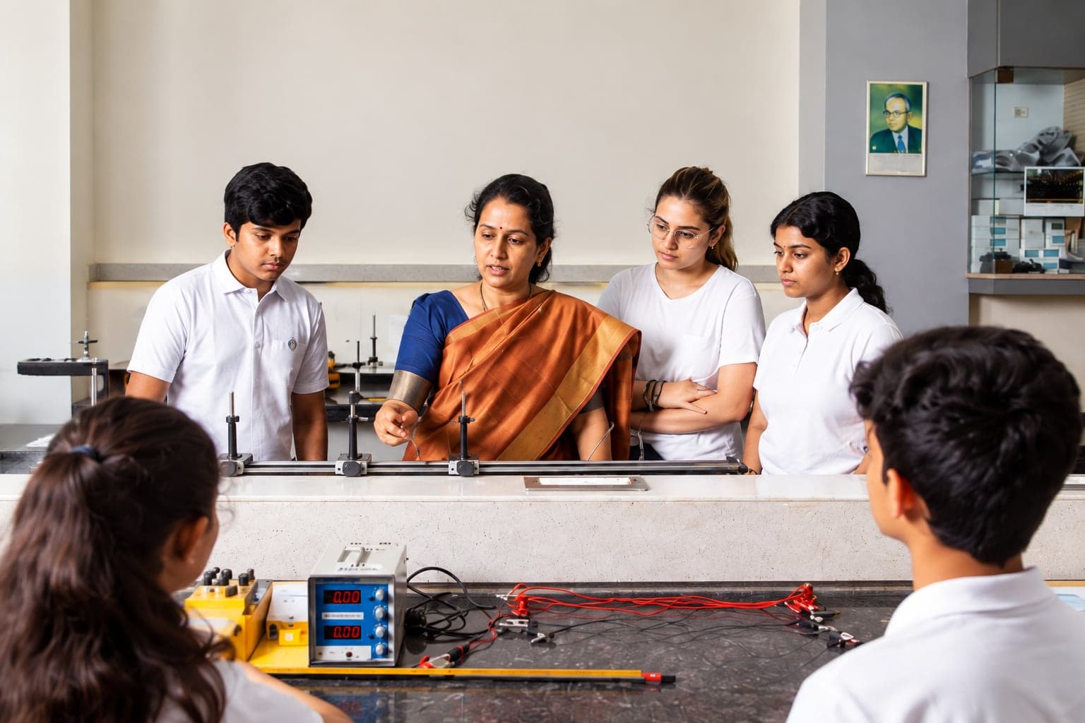 An ISC teacher guiding students during a physics experiment