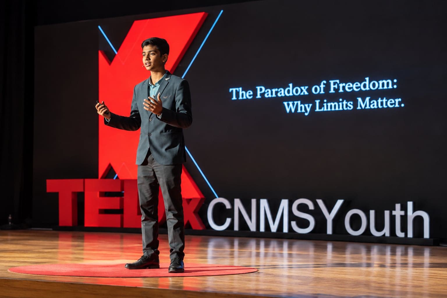 A student speaking on the TEDxCNMSYouth stage
